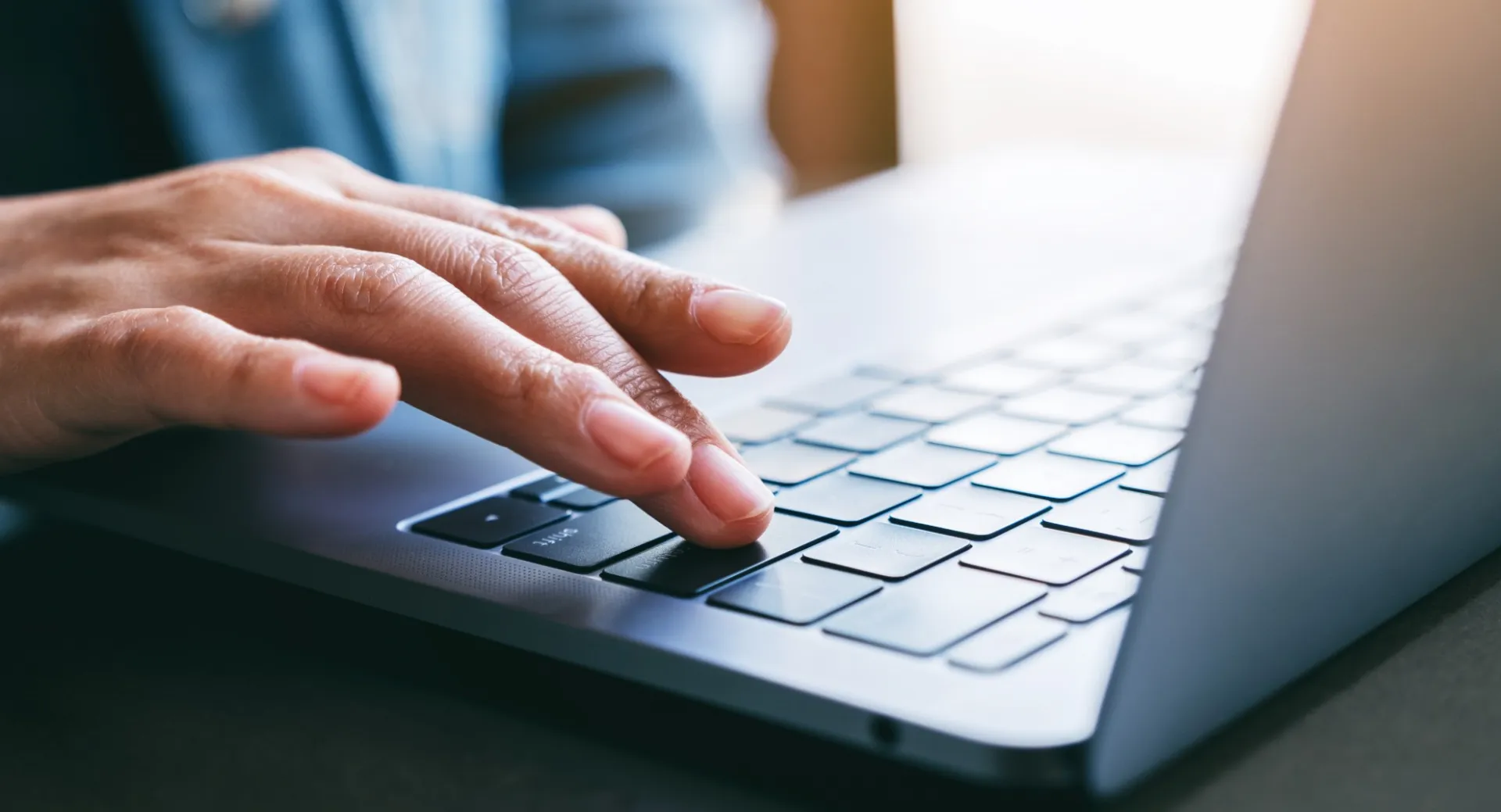 Hand typing on a laptop
