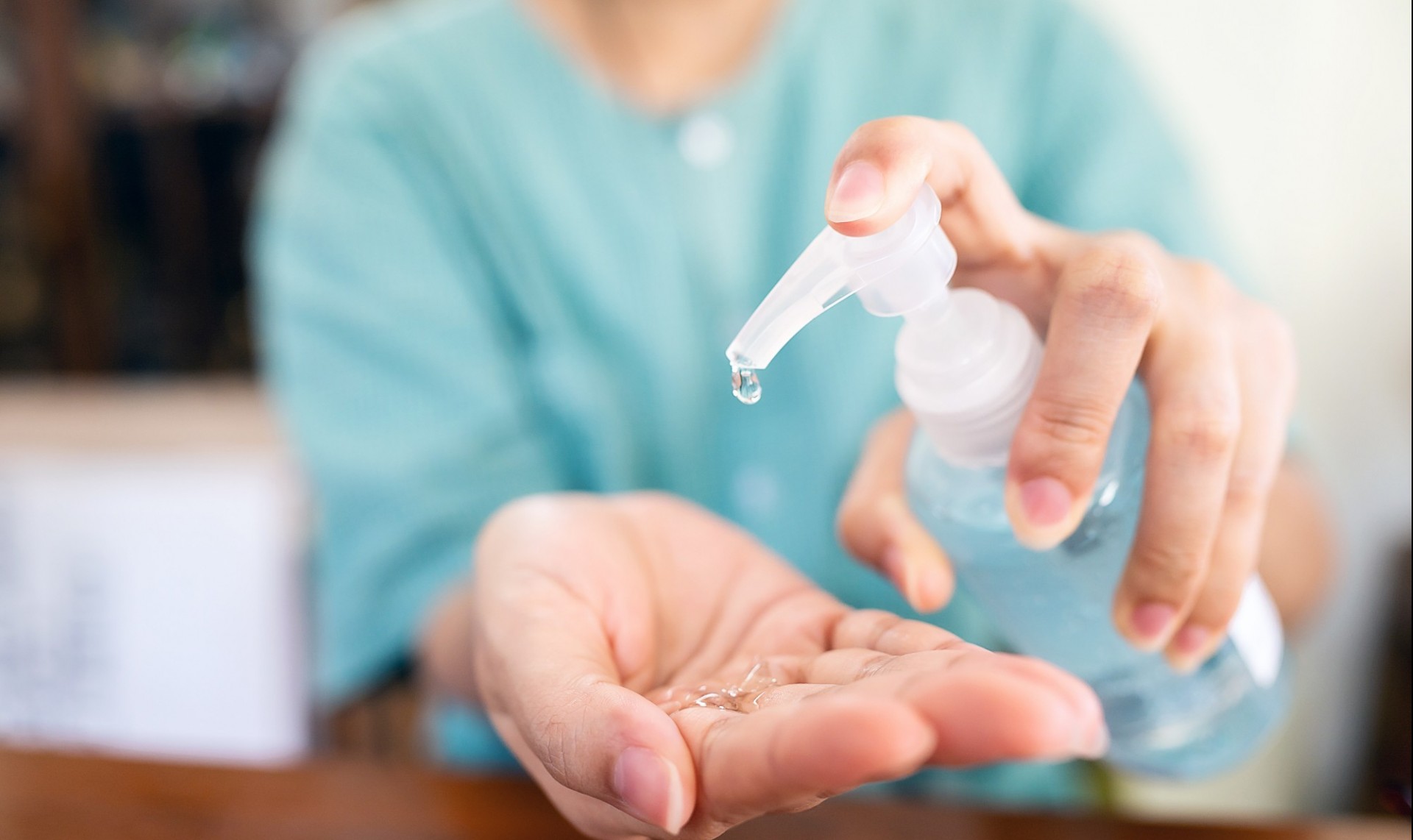 Woman holding out a bottle of hand sanitizer