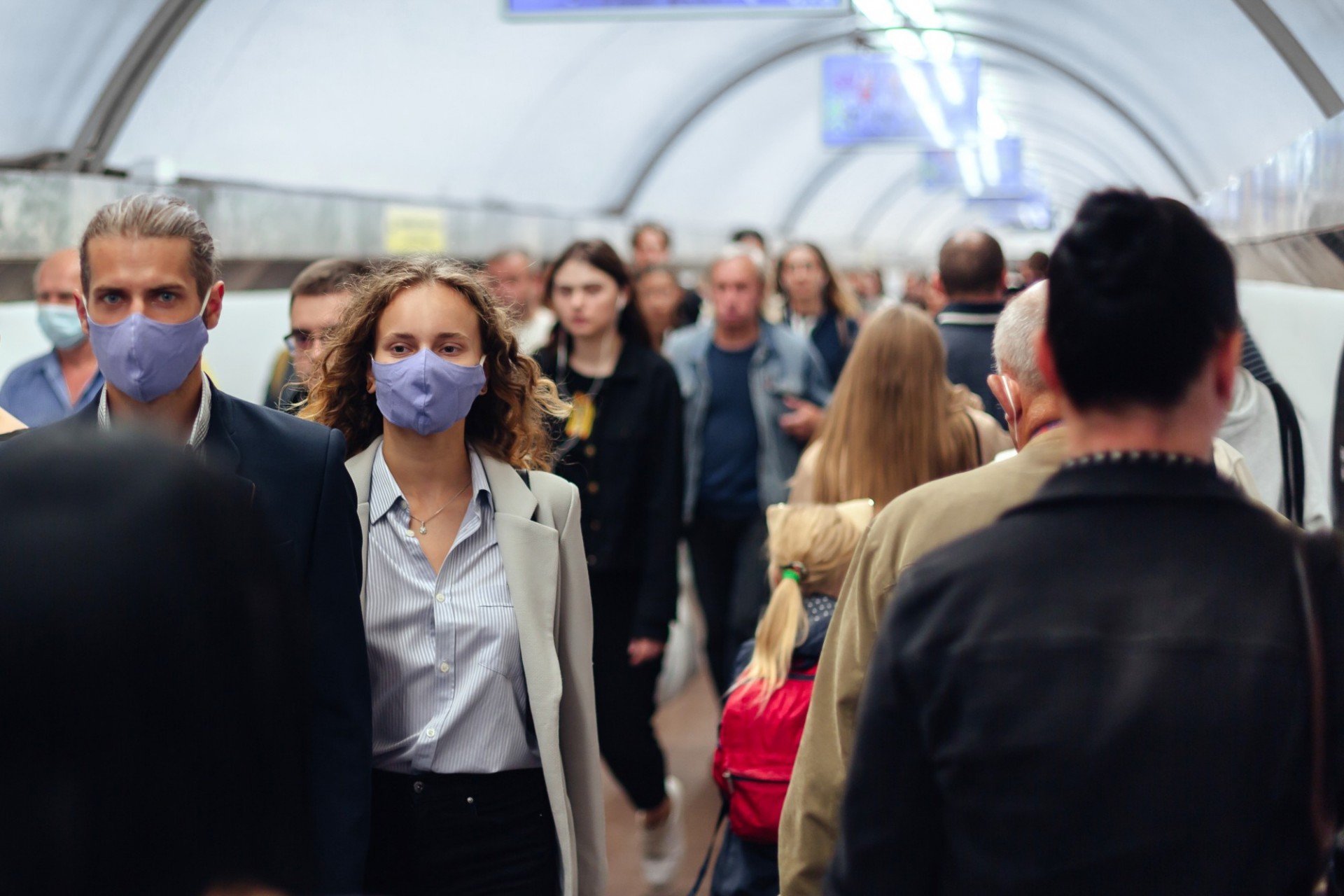 People in a crowded area, wearing masks